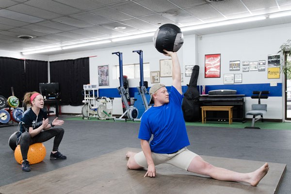 cheerleader guides a barefoot-split-medicine-ball-complex