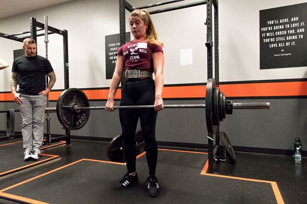 female lifter trains her deadlift