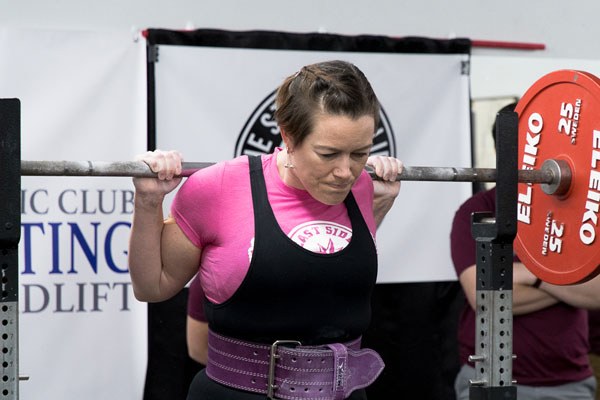 female lifter prepares to squat at a meet