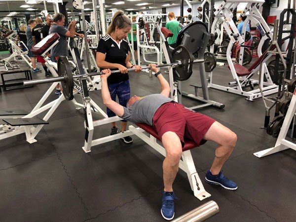 rebecca fishburne bench hand-off in a commercial gym