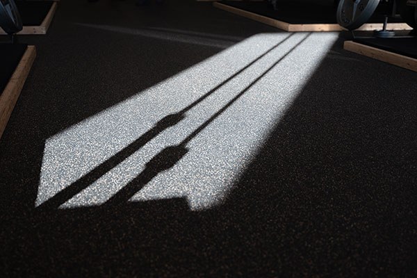 barbell shadow on a gym floor