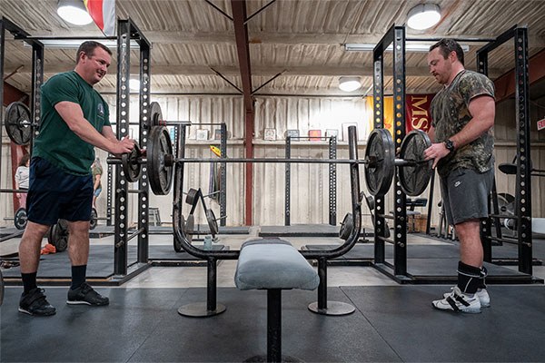 two lifters misloading the bar