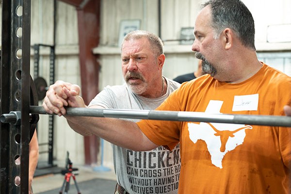 mark rippetoe coaching a lifter in the squat