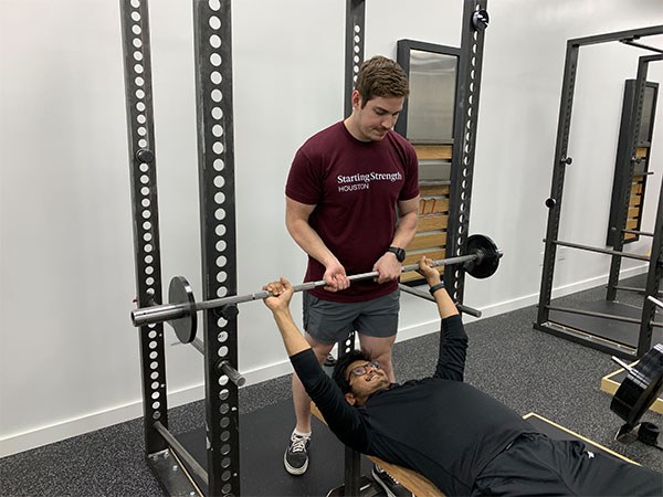 cody hands off the bar to sanath in the bench press