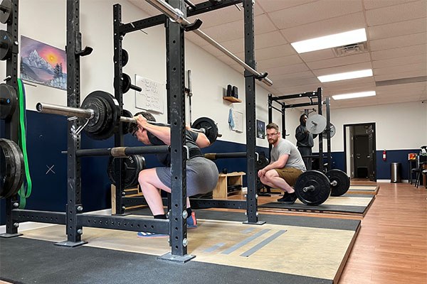 adam coaches ramona checking her squat depth