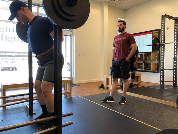 matt hebert coaching the squat at a training camp in san antonio