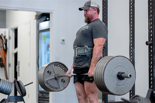 aaron frederick deadlifts during a staff training session at starting strength austin