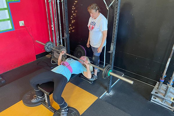 julie benches while sharon spots at testify strength and conditioning