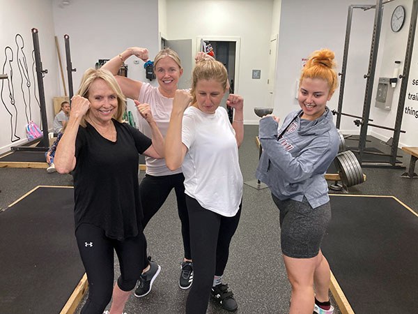 group photo of female lifters posing at starting strength houston