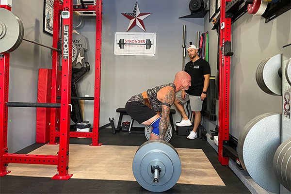 chris reviews the start position of the deadlift with dave