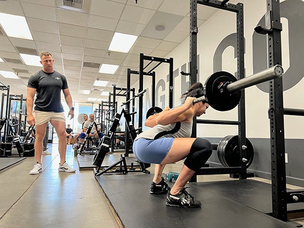 mike minigell coaches a squat at a starting strength training camp