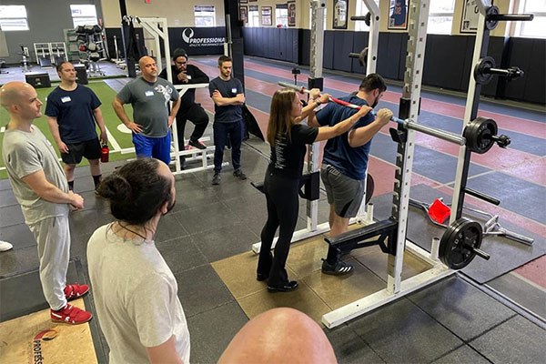 inna koppel teaches bar placement at a starting strength training camp