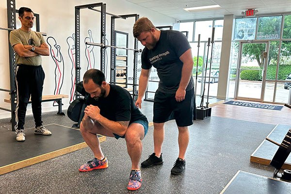 andrew lewis explains the critical position of the bottom of the squat