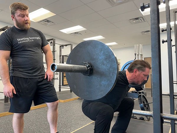 chris focuses on driving his hips out of the bottom of the squat
