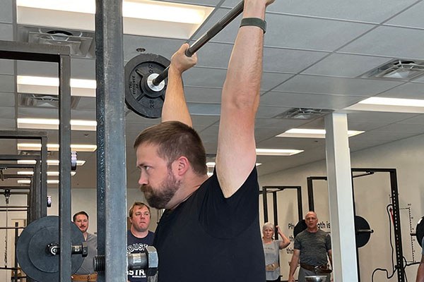 alex shrugs into the top of a press