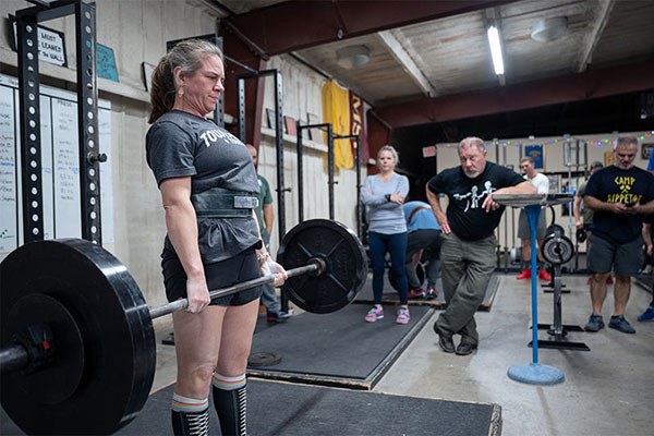 amelia locking out a deadlift at a starting strength seminar in texas