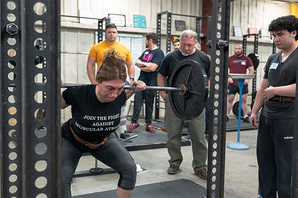 christine driving her hips as she approaches the top of a squat