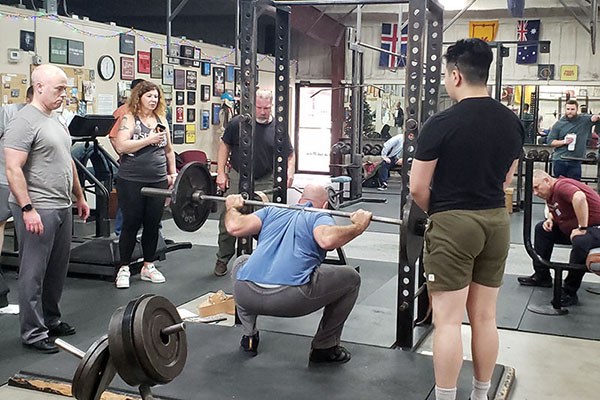 rip coaches a squat at the starting strength seminar