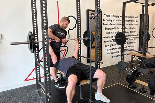 andrew hands off a bench press at the press training camp