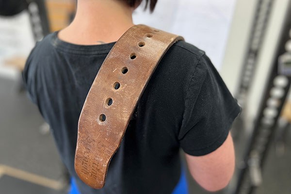 girl with a belt over her shoulder