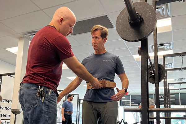 andrew adjusts the tightness of a trainee's belt