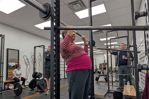 mary pressing against a power rack at starting strength columbus