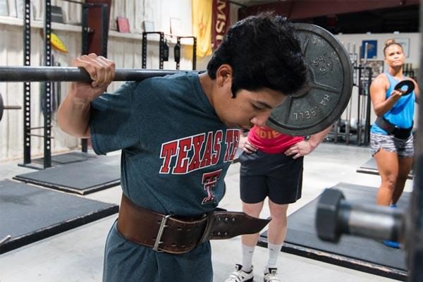 boy preparing to barbell squat