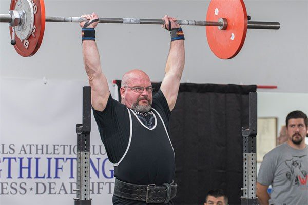 john musser locks out a press at a strength meet