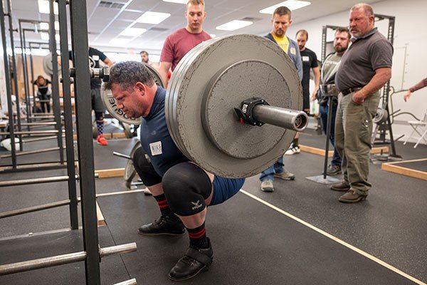 a lifter uses knees sleeves while squatting