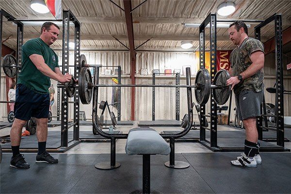 two lifters misloading the bar