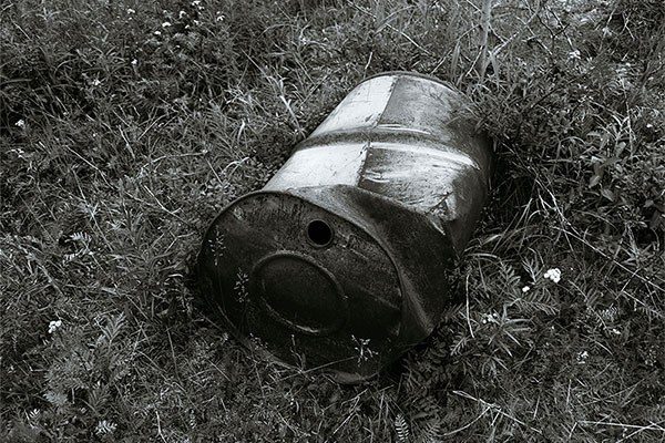used up oil barrel in a field