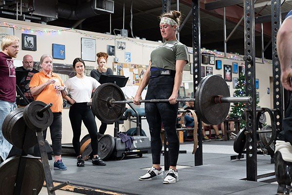 female lifter locking out a deadlift
