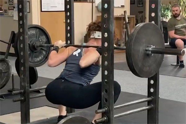 female lifter in the bottom of a squat