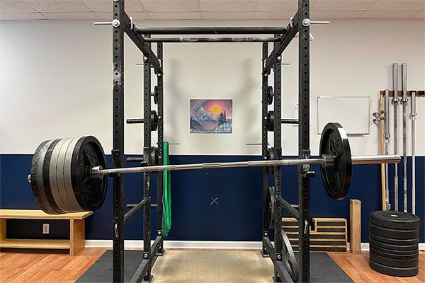 unevenly loaded barbell tipping in a rack