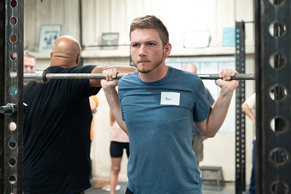 underweight novice under the bar preparing to squat