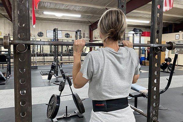 lifter taking the bar from the rack for a press