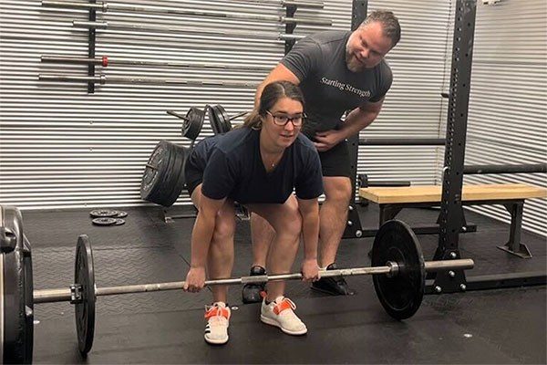 lifter being coached at the start of a deadlift