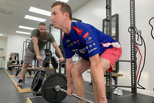 lifter being coached at the start of a deadlift