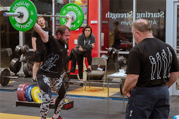 rip coaches a lifter in the snatch at the 2022 starting strength coaches conference