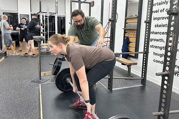 ssc coaching a lifter in the deadlift at a starting strength gym