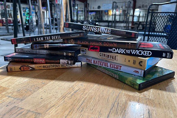 piles of dvds on a table in the gym