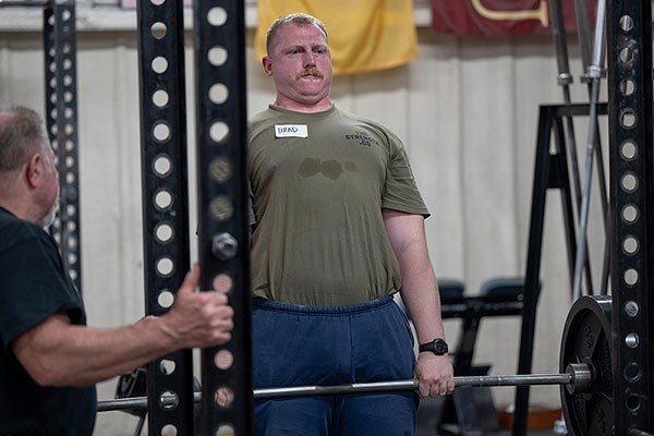 lifter finishing a pull while mark rippetoe coaches