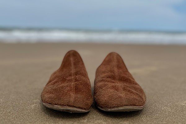 travel shoes on a beach