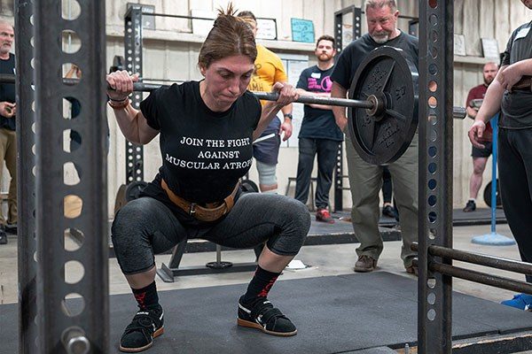 a lifter squats at the starting strength seminar