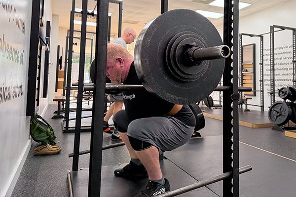 lifter at the bottom of his squat at starting strength katy